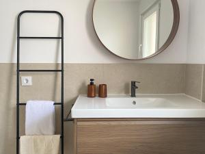 a bathroom with a sink and a mirror at Praia - Boa Onda in Cee +8 photos