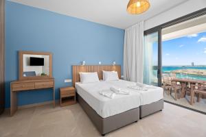 a bedroom with a bed and a view of the ocean at Kritamo Suites Sandy Bay in Ayia Napa +44 photos