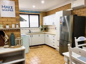 a kitchen with white cabinets and a stainless steel refrigerator at Champion Bay Coastal Stay in Geraldton