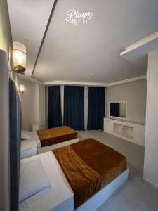 a hotel room with two beds and a tv at Playa Hotel in Dahab