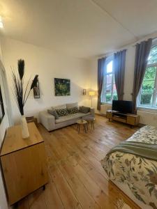a living room with a bed and a couch at Ferienwohnungen im Gutshaus Groß Upahl in Groß Upahl