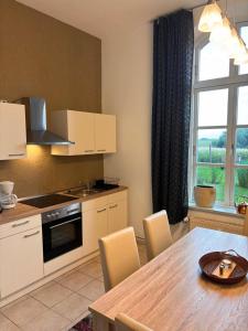 a kitchen with a wooden table and a dining room at Ferienwohnungen im Gutshaus Groß Upahl in Groß Upahl