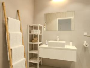 a bathroom with a sink and a mirror and towels at Apartment Rahat in Ližnjan