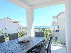 a dining table and chairs on the balcony of a house at Apartment Rahat in Ližnjan +17 photos