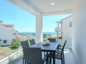 a table and chairs on a balcony with a view at Apartment Rahat in Ližnjan