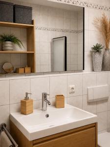 ein Badezimmer mit Waschbecken und Spiegel in der Unterkunft NOVA Living, Balkon, Nähe Altstadt & kostenlose Tiefgarage in Würzburg + 12 Fotos