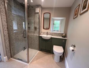 a bathroom with a shower and a toilet and a sink at Hinton Hayloft in Hinton in the Hedges