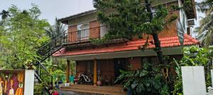 a house with a balcony on the side of it at BirdScapes Kumarakom Homestay in Kumarakom