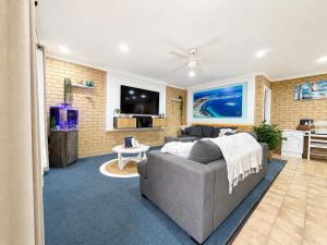 a living room with a couch and a tv at Champion Bay Coastal Stay in Geraldton