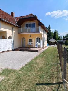 a house with a fence in front of a yard at Árvácska Nyaraló in Balatonmáriafürdő