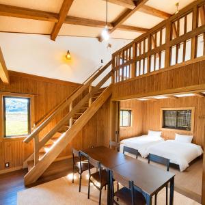 a room with a table and a bed and a staircase at Setouchi Retreats Sera Highlands in Egi