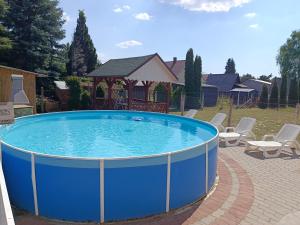 a large blue pool with a gazebo at Árvácska Nyaraló in Balatonmáriafürdő