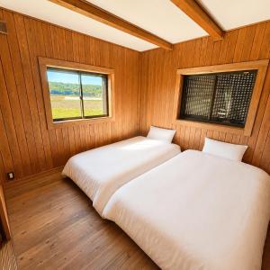 two beds in a room with a window at Setouchi Retreats Sera Highlands in Egi