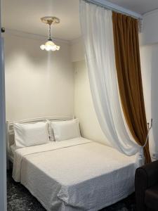 a bedroom with a white bed and a curtain at Boutique Sea & Garden in Vari