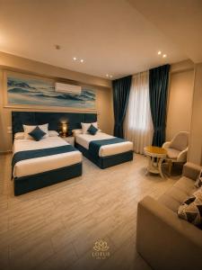 a hotel room with two beds and a couch at Grand lotus hotel downtown in Cairo