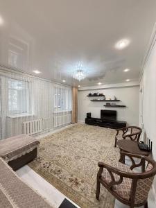 a large living room with a couch and a television at Jaily in Astana