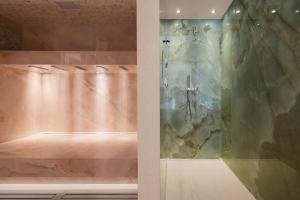 a bathroom with a shower with a glass door at Hôtel Cala di Greco in Bonifacio +95 photos