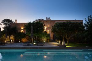 a building with a swimming pool in front of a building at Masseria Borgo Mortella in Lecce