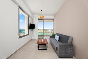 a living room with a couch and a table at Kritamo Suites Sandy Bay in Ayia Napa