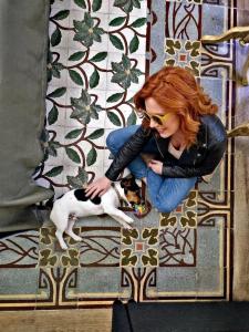 a woman sitting on the floor petting a dog at Kèramos Luxury Rooms in Sciacca