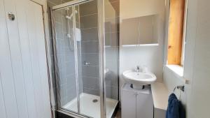 a bathroom with a shower and a sink at Stornoway Stays Apartment in Stornoway +3 photos