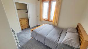 a small bedroom with a bed and a window at Stornoway Stays Apartment in Stornoway