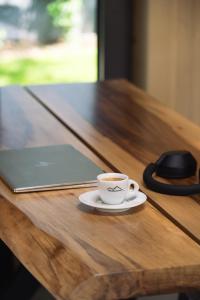 a cup of coffee sitting on a table with a laptop at Kabata 2620 ` Кабата 2620 in Bansko