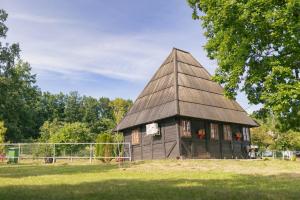 a small building with a gambrel roof in a field at Brvnara Jez in Kraljevo