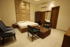 a bedroom with a bed and a desk and a chair at Meenar Hotel in Meerut