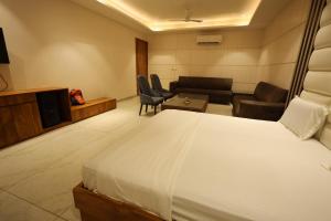 a hotel room with a bed and a living room at Meenar Hotel in Meerut
