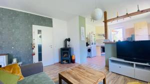 a living room with a flat screen tv and a table at BergZeit in Warbach