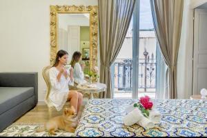 a woman sitting on a chair in a hotel room at Kèramos Luxury Rooms in Sciacca