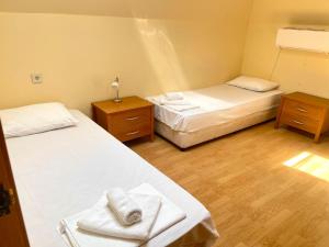two beds in a room with two tables and towels at Balchik English House in Balchik +25 photos