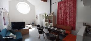 a living room with a couch and a keyboard at Gîte La Cour Cachée in Saulx-en-Woëvre
