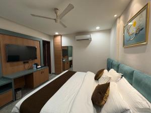 a bedroom with a bed and a flat screen tv at Hotel Bella Vento Luxury Stay Near CGC Landran Mohali Chandigarh in Kharar