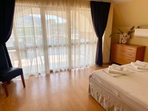 a bedroom with a bed and a dresser and a window at Balchik English House in Balchik
