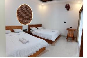 two beds in a room with white walls at Tereng Wilis Jungle Inn in Tetebatu +143 photos