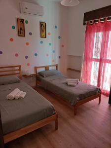 a bedroom with two beds and a wall with polka dots at Villa Alma in Bari