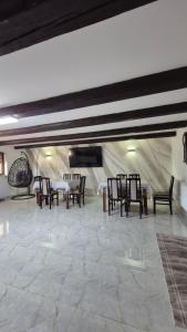 a dining room with chairs and tables in a building at Piatra Humorului in Mănăstirea Humorului
