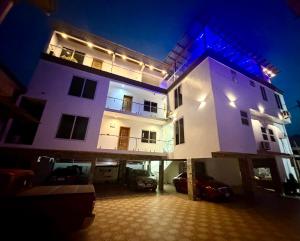 a large white building with a parking lot at night at Bonsukoda Lodge in Accra