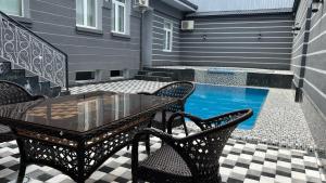 a patio with a table and chairs and a pool at Art Tashkent Hotel in Tashkent