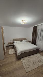 a bedroom with a large bed and wooden floors at Piatra Humorului in Mănăstirea Humorului