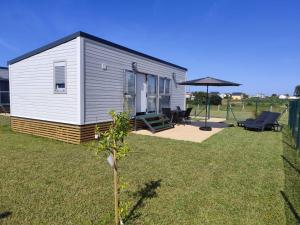 a tiny house in a yard with a patio at Balea House in Barreiros