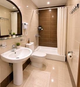 a bathroom with a sink and a toilet and a tub at Guest House Gardenia & Wine Cellar in Lagodekhi +41 photos