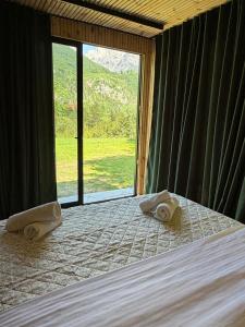 a bedroom with a bed with towels on it at Villa Ujëvara e vogël in Theth