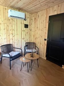 a room with two chairs and a table and a door at Villa Ujëvara e vogël in Theth +78 photos