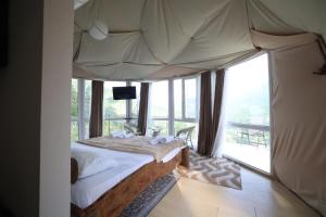 a bedroom with a canopy bed with a large window at Akho Panorama in Batumi +43 photos