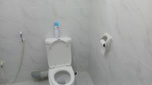 a bathroom with a toilet with a blue bottle on it at Hermit Homes in Mombasa +17 photos