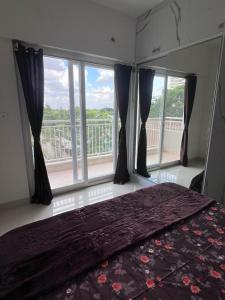 a bedroom with a bed and a large window at Beruru Homes- 2BHK Apartment near Bengaluru Airport in Devanhalli +15 photos
