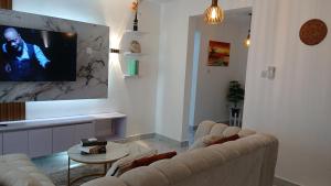 a living room with two couches and a flat screen tv at Hermit Homes in Mombasa